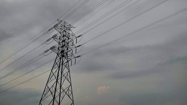 istock Electrical power line tower with electrical power cable in urban area during cloudy day 2143423568
