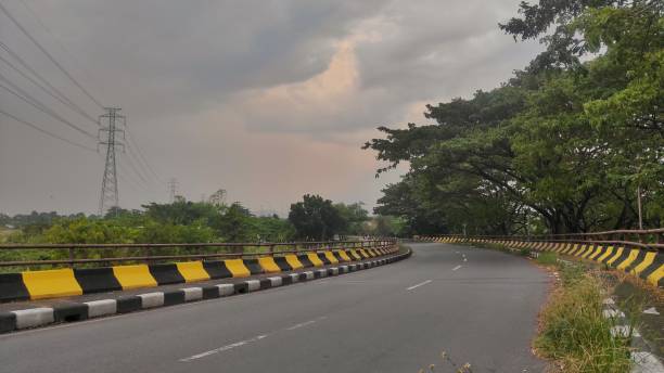 istock Empty fly over street with surrounded by tree during cloudy day 2143423579