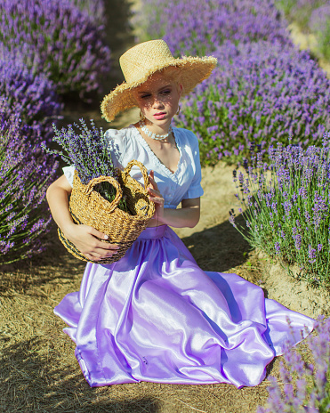 Blonde woman in purple dress on lavender field.
