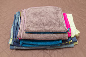 A pile of towels and linen on a bed