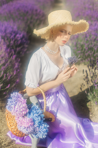Blonde woman in purple dress on lavender field.