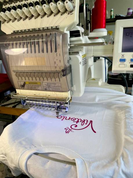 istock machine embroidery of a logo on a T-shirt with purple threads 2143443584