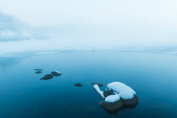 A body of water, Radasjon Lake in Sweden, covered in snow and ice during the winter season. The icy surface reflects the cold atmosphere, creating a stark and wintry landscape.
