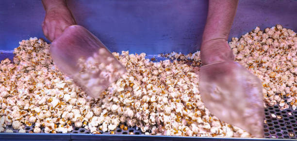 Fresh Kettle Popcorn: Operator mixes it with salt and perhaps sugar allowing unpopped waste kernels to fall through the holes in the sifting tray. The serving scoops are used to mix it but will also be used to fill plastic sleeves to sell to customers.