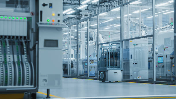 istock 3D Render: Automated Support Vehicles Transport Electrical Components, Circuit Boards and Microchips. Separate Facility with an Assembly Line Producing High Quality Precise Equipment with Robotic Arms 2143488938
