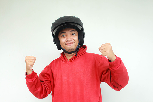 Young Asian man happy and excited gesture while wear a motorcycle helmet. Safety concept.