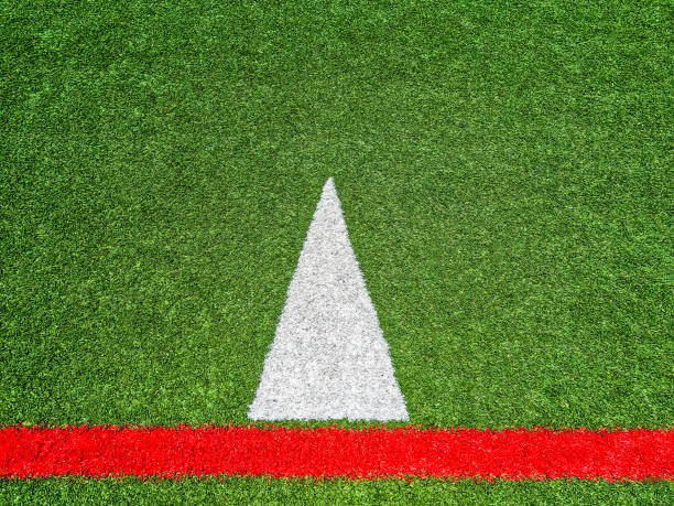 Artificial turf soccer pitch close-up with a crisp white boundary line on vibrant green synthetic grass, empty professional playing surface for sport, training, or recreation