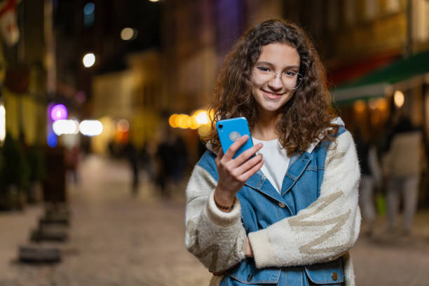istock Happy girl using smartphone typing text messages browsing internet finishing work looking at camera 2143515045