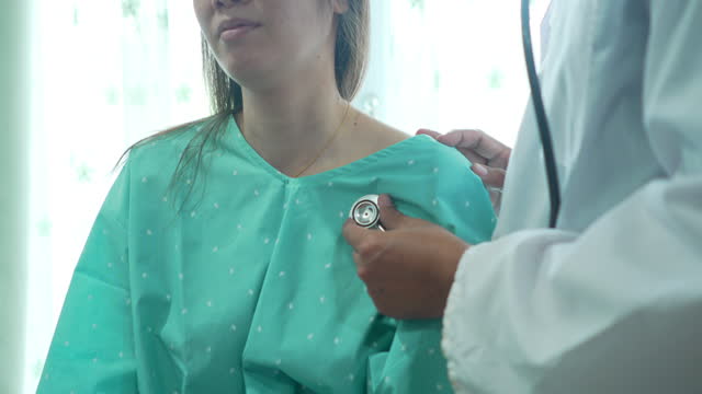 Doctor Listening to Patient's heart and  lungs  with a stethoscope.