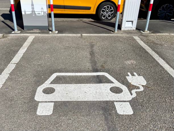 Outdoor public parking spot with a painted white EV charging symbol on the ground in Freiburg, Germany