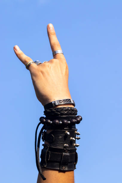 istock Man on rock with wristbands and with hand symbol 2143544401