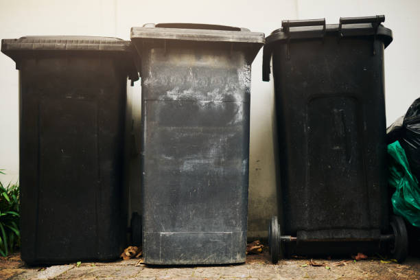 istock Three black rubbish bins against a white wall with copy space. Stock photo 2143553803
