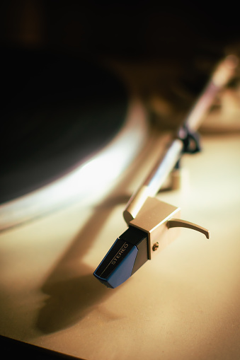 Close-up of a turntable tonearm. Concept of stereo music, analog sound, audiophiles, album music, and retro record players.