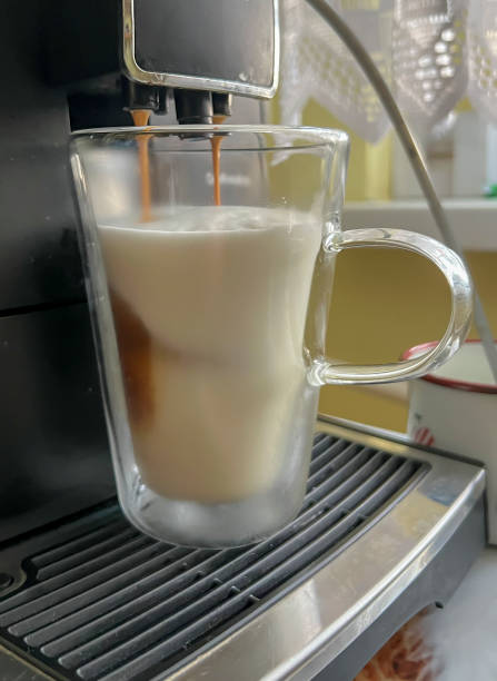 istock Coffee with milk poured from a coffee machine into a transparent, double-walled thermal mug 2143582700