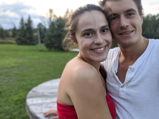 istock A couple smile at the camera on a grass field 2143691005