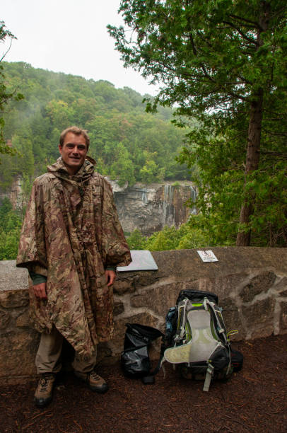 istock A man smiles at the camera in front of a waterfall 2143702854