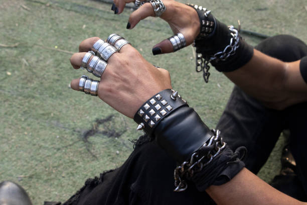 Man on rock with wristbands and with hand symbol