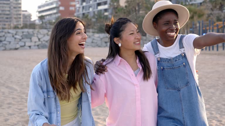 Female friends walking and spending time together on the beach.