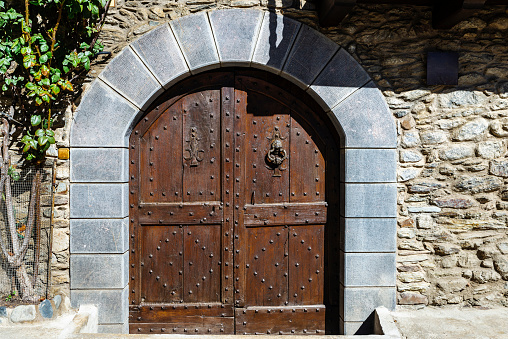 Old wooden door of a typical house of the rustic village of Esterri Aneu, Lleida, Catalonia, Spain