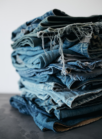 A stack of folded blue denim jeans. Stock photo