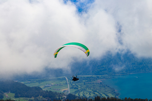 Paraglider flying from Niederhorn mountain in Swiss Alps, Switzerland. Concept of active lifestyle and extreme sport adventure