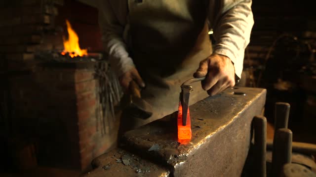 Blacksmith on an Anvil Forges Hot Iron, Makes a Horseshoe.
