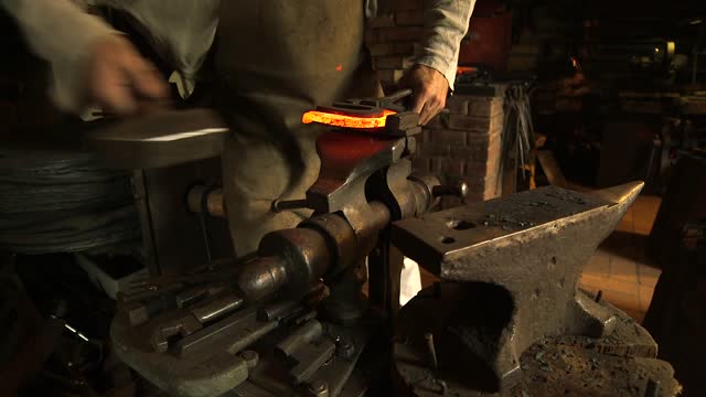 Blacksmith on the Anvil Forging a Hot Horseshoe.