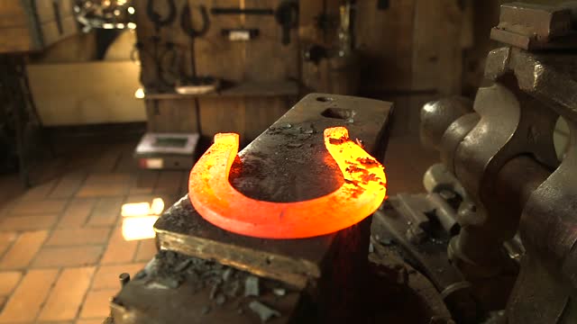 Blacksmith Takes a Flaming Horseshoe from the Furnace and Places it on Anvil.