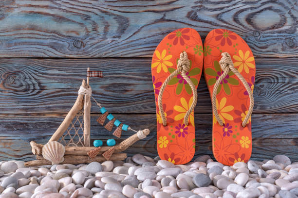 Close up photo of green flip flop slippers on red background. No people are seen in frame. Shot in studio.