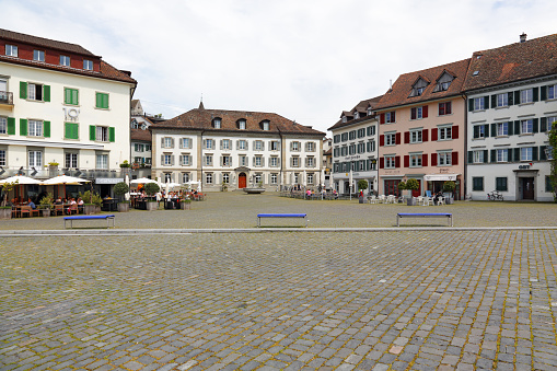 Rapperswil, Switzerland - 10 May 2016: Historic buildings around the Fish Market Square. There are people sitting outside in various cafes and restaurants.