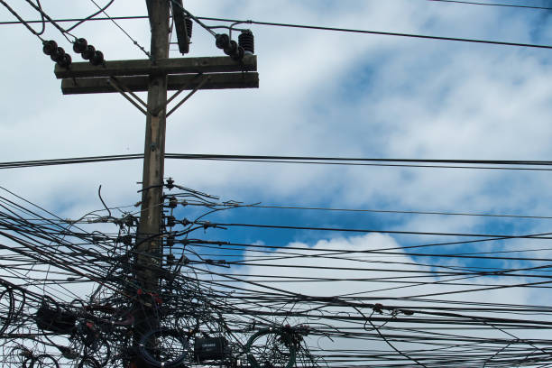istock Chaotic power lines on a pole against a cloudy sky in Thailand 2144085976
