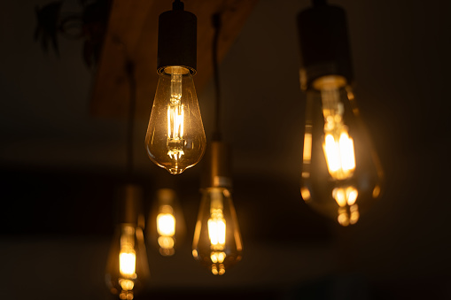 Light bulb handing on a dark background