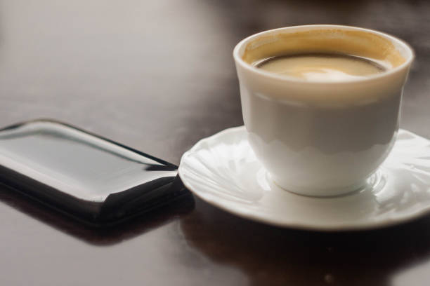 a cup of coffee and a phone on the table