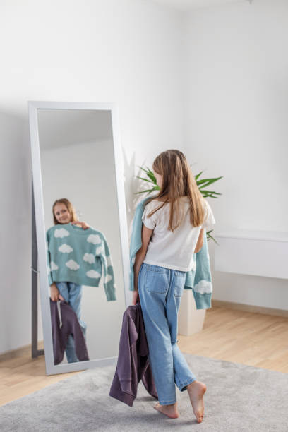 istock Choosing Outfits: Child with Clothes by Mirror. Morning preparation before school. 2144174179