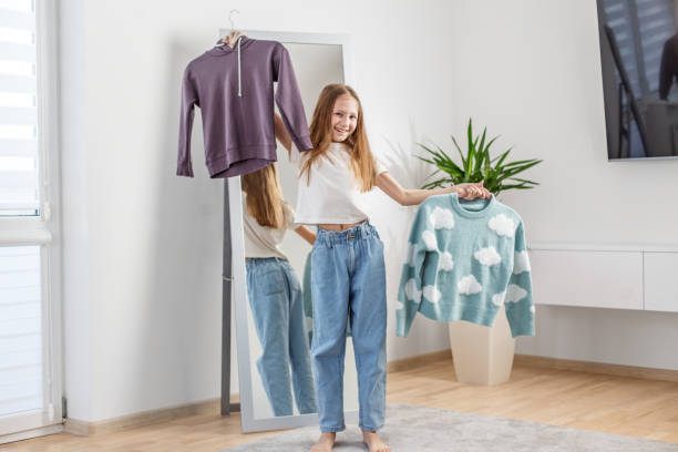 istock Choosing Outfits: Girl with Clothes. Morning preparation before school. 2144174188