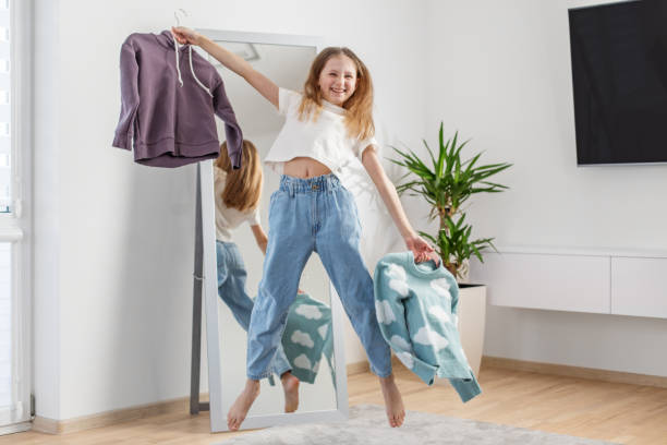 istock Child Jumping While Choosing Sweaters in Her Room. Morning preparation before school. Having fun. 2144174190
