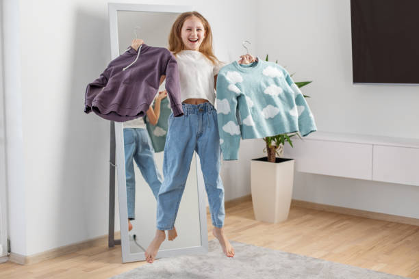 istock Child Jumping While Choosing Sweaters in Her Room. Morning preparation before school. Having fun 2144174195