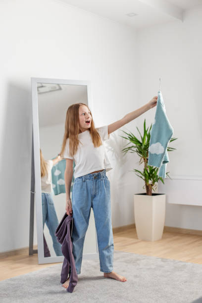 istock Excited Young Child Picking Outfit by Mirror. Morning preparation before school. 2144174196