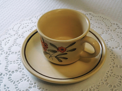 Collection of 22 retro cups of coffee decorated with flowers placed on a table