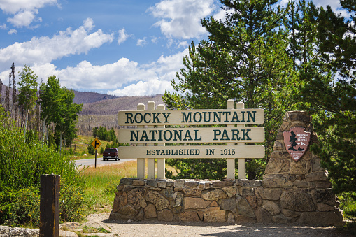 Colorado, USA: July 22, 2023: Entrance sign to Rocky Mountain National Park with a majestic mountain panorama behind it.