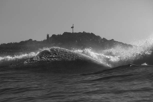 Heavy seas at Peggy's Cove Lighthouse in morning sunlight.