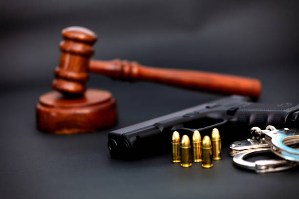 istock Hand gun weapon and judges gavel. 2144402854