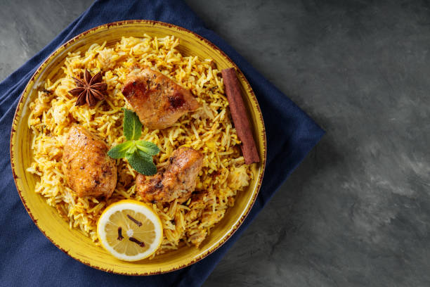 istock Delicious Indian Dish Chicken Biryani with Spices and Lemon on Yellow Plate, Copy Space 2144459676