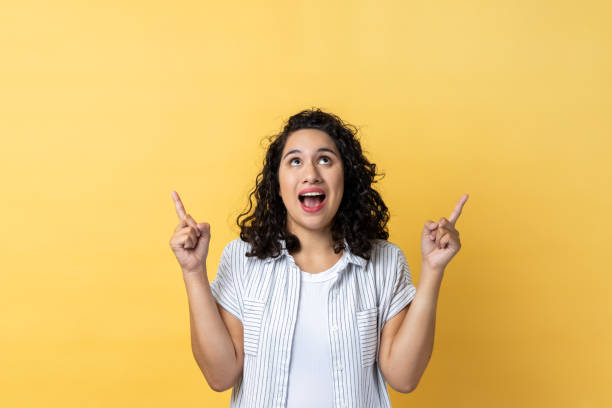 istock Woman pointing up at empty place for ad content and expressing astonishment. 2144527734