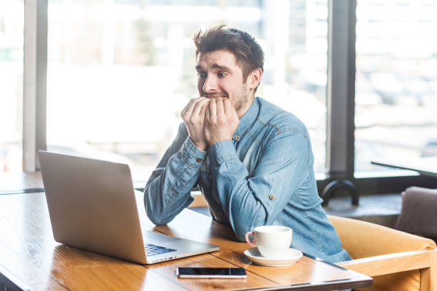 istock Man working on laptop, looking at display, biting his finger nails, waiting for interview results. 2144528287