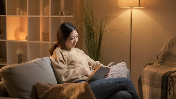 istock Book lover home rest smart woman reading novel 2144535945