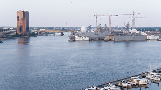 A view of Pearl Harbor, Hawaii, from the back of a navy launch docked at the U.S.S. Arizona memorial. The American flag is at the rear of the launch; in the distance on the right is the U.S.S. Missouri, on which the surrender of Japan was signed in 1945.