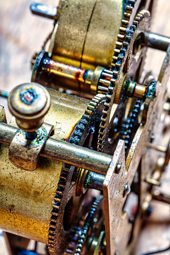 The clockwork innards of a timepiece display an intricate network of gears, aged yet precise