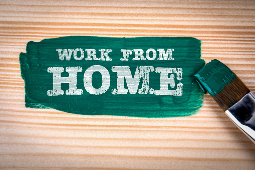 Work From Home. Green paint and paint brush on wood texture background.