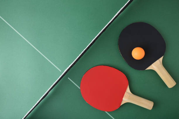 istock Ping pong paddles and ball on green game table 2144646667